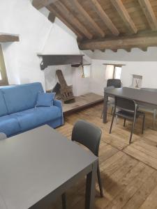 uma sala de estar com um sofá azul e mesas em Mulini di Verrucole em Naggio