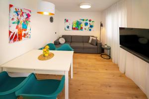 a living room with a white table and blue chairs at Apartment Noa Malinska in Vantačići