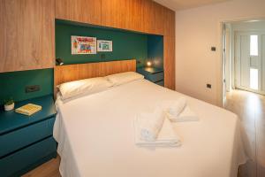 a bedroom with a white bed with towels on it at Apartment Noa Malinska in Vantačići