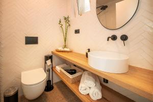 a bathroom with a sink and a toilet and a mirror at Apartment Noa Malinska in Vantačići