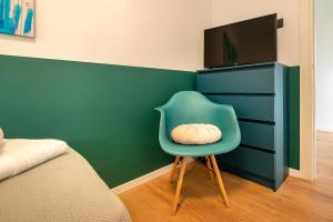 a blue chair with a pillow on it next to a dresser at Apartment Noa Malinska in Vantačići