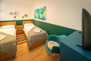 um quarto de hospital com duas camas e uma televisão em Apartment Noa on island Krk em Vantacići