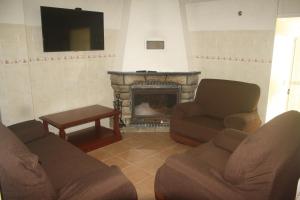 a living room with two couches and a fireplace at CasaTioManel in Amiães de Baixo