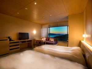 鳥羽市にある心に宿る芭新萃のベッド2台とテレビが備わるホテルルームです。