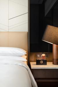 ein Schlafzimmer mit einem Bett und einer Lampe sowie einem TV in der Unterkunft Renaissance Xi'an Hotel in Xi'an