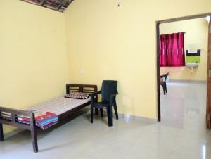 a bedroom with a bed and a chair and a mirror at The Grace Guest House in Salcete