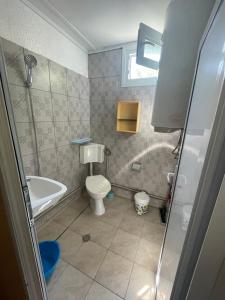 La salle de bains est pourvue de toilettes, d'une baignoire et d'un lavabo. dans l'établissement Bungalow Silitur, à Ahtopol