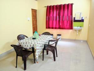 a dining room with a table and chairs and a sink at The Grace Guest House in Salcete