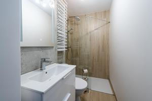 ein Badezimmer mit einem weißen Waschbecken und einem WC in der Unterkunft Apartament Crab Sopot Kamienny Potok in Sopot