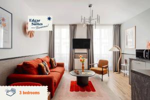 sala de estar con sofá rojo y mesa en Edgar Suites Saint-Lazare - Amsterdam, en París