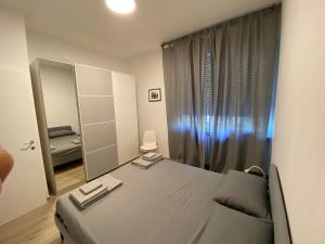 Schlafzimmer mit einem weißen Bett und einem Spiegel in der Unterkunft Casettadellafotografia in Senigallia