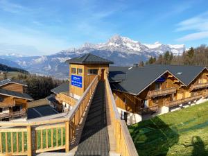 a view of a lodge with mountains in the background at Goélia Les Chalets des Pistes in Combloux