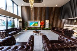 uma sala de espera com sofás de couro e uma televisão em Blue Vista Hotel & SPA em Esenyurt