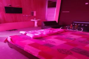 a pink room with a bed and a chair at SPOT ON Stacy Guest House in Jīnd