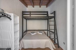 ein Schlafzimmer mit einem Etagenbett mit einer Leiter in der Unterkunft La Tabarchina - Carloforte Lovely Apt With Terrace! in Carloforte