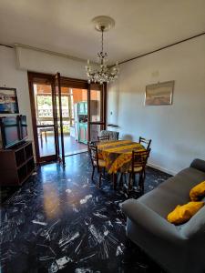 a living room with a dining room table and a couch at Luminoso appartamento vacanze vista mare in centro in Celle Ligure