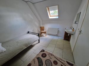 a small bedroom with a bed and a sink at Borger appartement in centrum dorp. in Borger