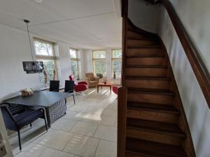 - un escalier dans le salon avec une table et des chaises dans l'établissement Borger appartement in centrum dorp., à Borger