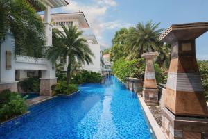 a swimming pool in front of a building with palm trees at Good View Hotel Tangxia - 15 mins drive from Dongguan South Railway Station in Dongguan