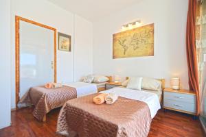 a hotel room with two beds and a mirror at Apartmani Niki Hvar in Hvar
