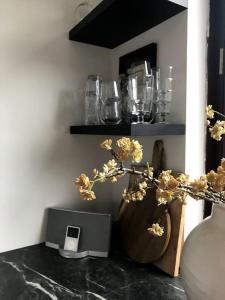 a vase with flowers on a table next to a shelf at Near Amsterdam and airport, 90m2, privacy! in Hoofddorp