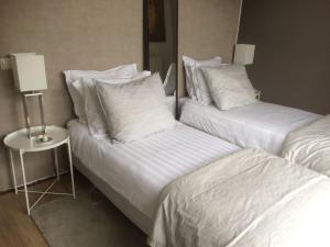 two beds in a hotel room with white sheets and pillows at Near Amsterdam and airport, 90m2, privacy! in Hoofddorp