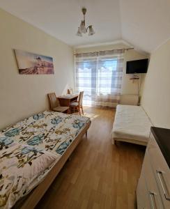 1 dormitorio con 1 cama, mesa y sillas en Dom Gościnny Roksana, en Rewal