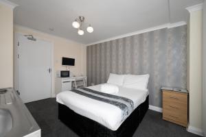Schlafzimmer mit einem Bett, einem Waschbecken und einer Badewanne in der Unterkunft Flexistay Tulsi Aparthotel in Croydon