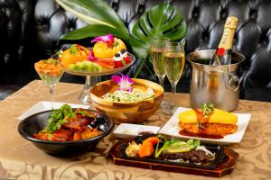 a table with plates of food and glasses of wine at Hotel Artia Dinosaur hirakata -Adult Only in Hirakata