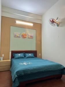 a bedroom with a blue bed in a room at Bình Minh Motel in Pleiku
