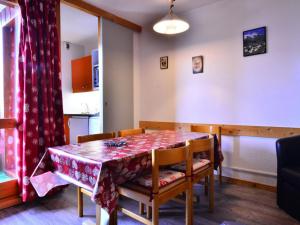 a dining room with a table and chairs with a red table cloth at Charmant appartement rénové 2/3 pièces pour 5 pers, proche pistes et commerces, parking gratuit - FR-1-329-29 in Bellentre