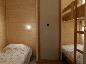 a bedroom with two bunk beds and a ladder at Charmant appartement rénové 2/3 pièces pour 5 pers, proche pistes et commerces, parking gratuit - FR-1-329-29 in Bellentre