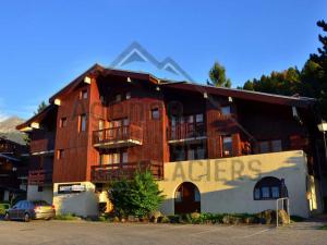 a large brick building with a parking lot in front of it at Charmant appartement rénové 2/3 pièces pour 5 pers, proche pistes et commerces, parking gratuit - FR-1-329-29 in Bellentre