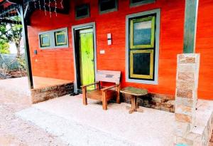 a red building with a bench and a bench at Pine tree house in Jember