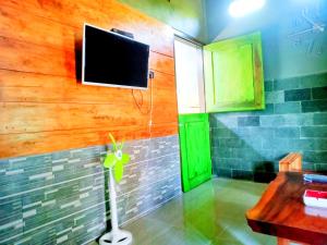 a bathroom with a flat screen tv on the wall at Pine tree house in Jember