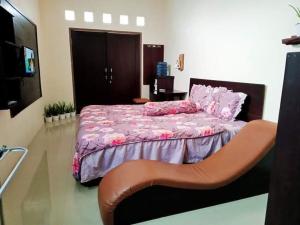 a bedroom with a bed with a high heelinylinylinylinylinylinylinyl at Pine tree house in Jember