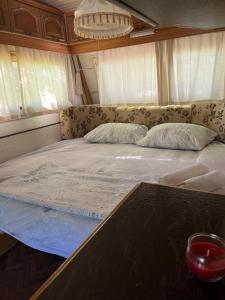 a large bed in a room with a table at KAMP-PRIKOLICA in Donji Štoj