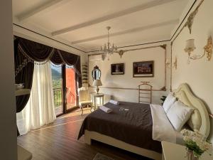 a bedroom with a bed and a balcony at Pesvebi Design Hotel and Cellar in Borjomi