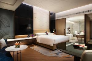una camera con un grande letto e un grande specchio di Renaissance Xi'an Hotel a Xi'an
