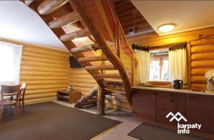 eine Küche mit einer Treppe in einem Blockhaus in der Unterkunft Золото Карпат in Izky