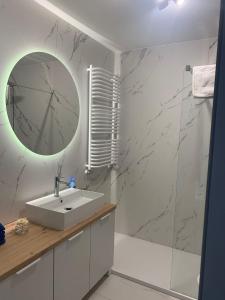 a bathroom with a sink and a mirror at Apartament Hebanowa in Swarzędz