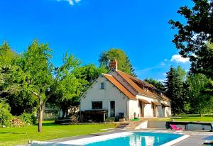 uma casa com uma piscina em frente em Longère normande, parc, piscine. em Montchevrel