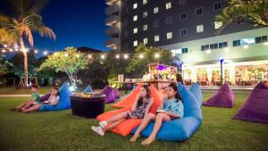 a group of children sitting on inflatable chairs in the grass at ASTON Cirebon Hotel and Convention Center in Cirebon