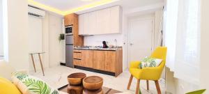 a living room with a yellow chair and a kitchen at ESTEPONA RADA BEACH ABC APARTMENTS & ESTUDIOS A in Estepona