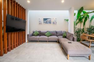 uma sala de estar com um sofá e uma televisão de ecrã plano em Green Villa Canggu em Canggu