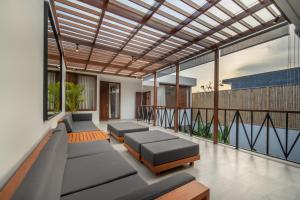 uma sala de estar com sofás e uma varanda em Green Villa Canggu em Canggu