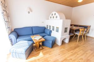 sala de estar con sofá azul y casa de juegos en Appartments Bergland en Bad Kleinkirchheim