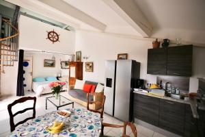 a kitchen with a table and a refrigerator at Duplex vue mer plage de Saint-Clair in Le Lavandou