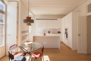 eine Küche und ein Esszimmer mit einem Glastisch und Stühlen in der Unterkunft FLH Downtown Central Boho Flat in Lissabon