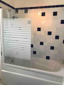 a bathroom with a shower and a tub with a window at Duplex vue mer plage de Saint-Clair in Le Lavandou